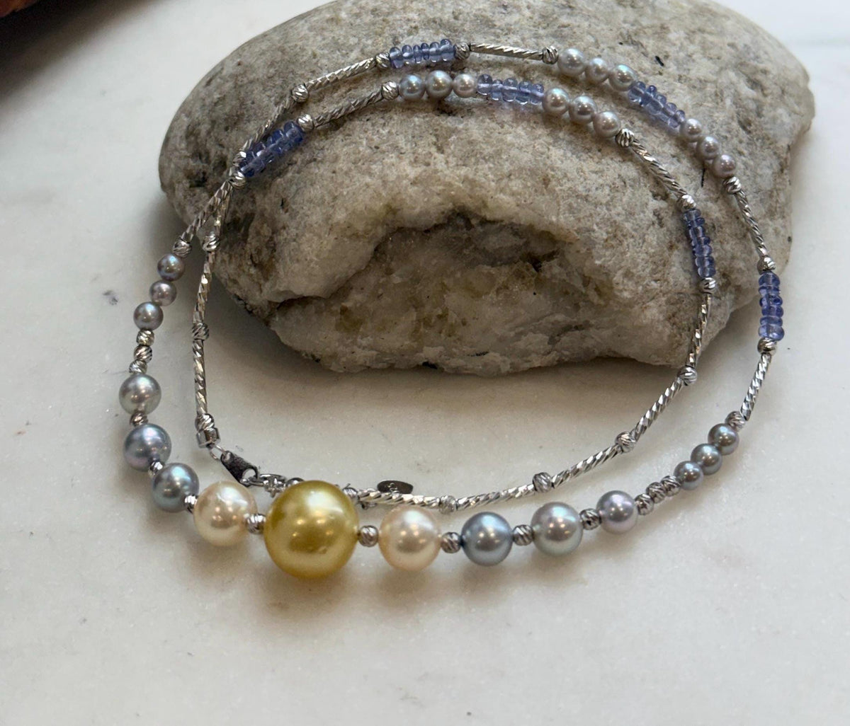 Saltwater pearl necklace with a golden center pearl and blue tanzanite beads.
