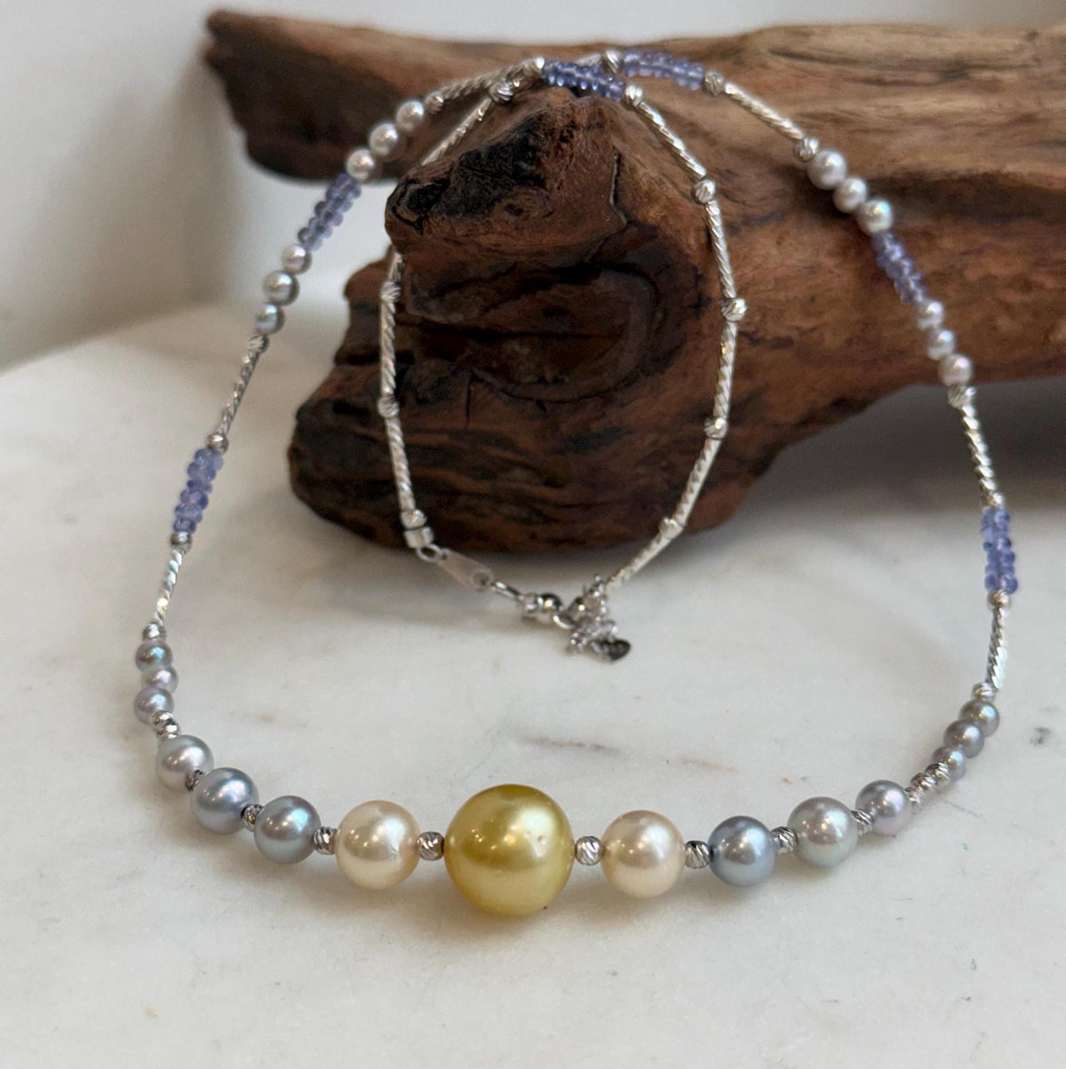 Saltwater pearl necklace with a golden center pearl and blue tanzanite beads.