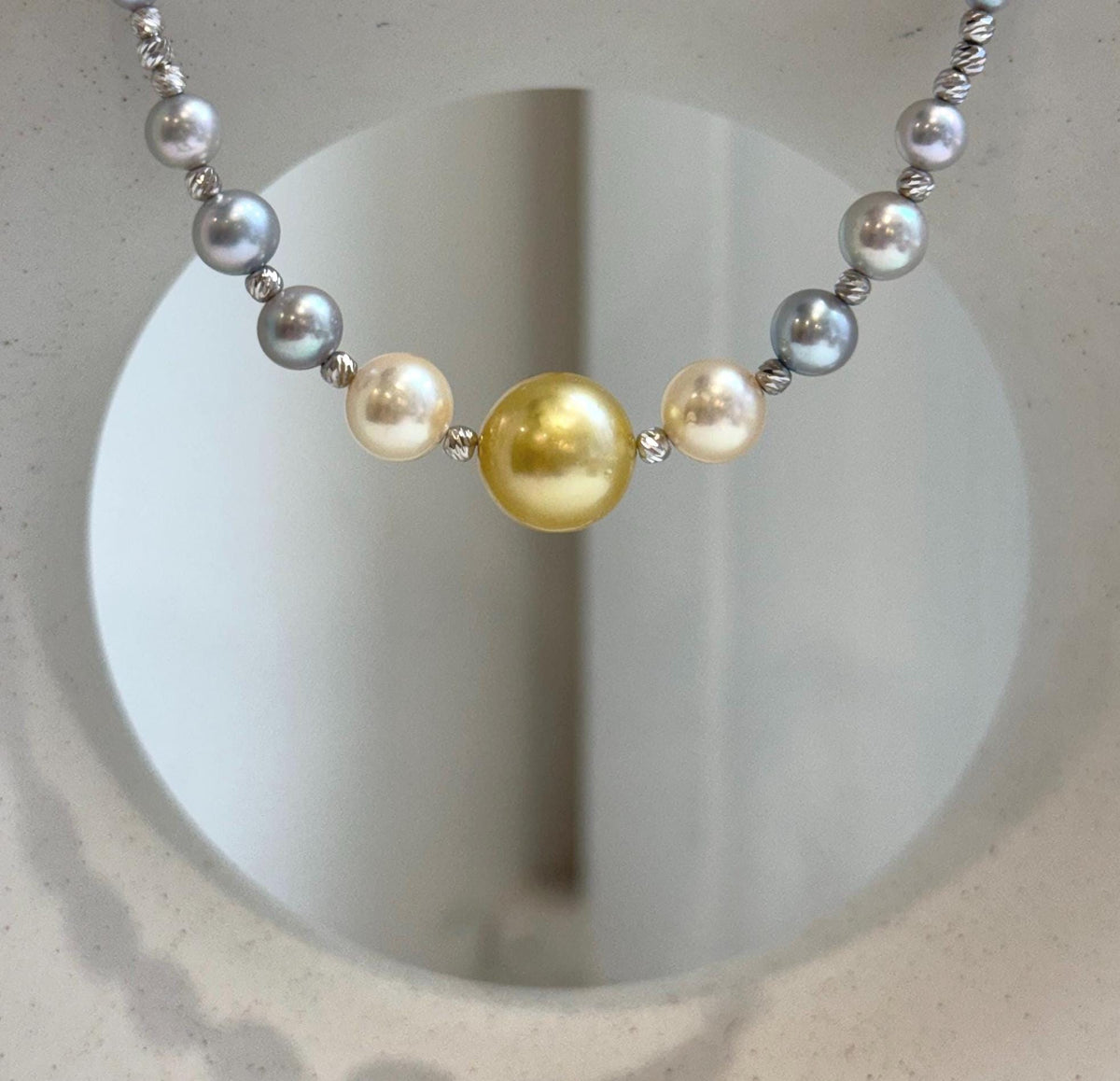 Saltwater pearl necklace with a golden center pearl and blue tanzanite beads.
