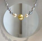 Saltwater pearl necklace with a golden center pearl and blue tanzanite beads.