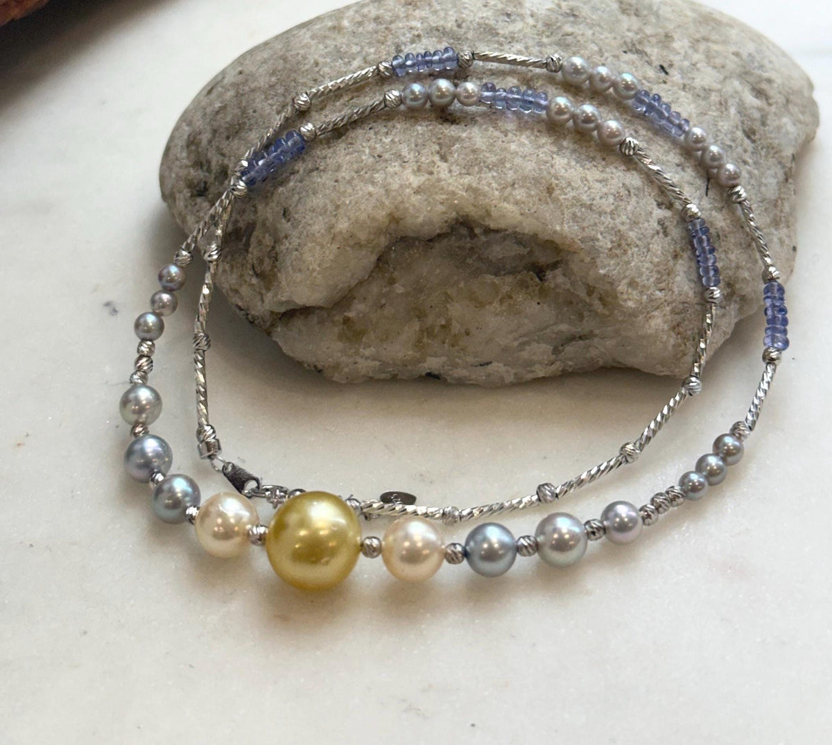 Saltwater pearl necklace with a golden center pearl and blue tanzanite beads.
