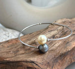 Slim S925 sterling silver bangle with round ocean pearls at both ends.