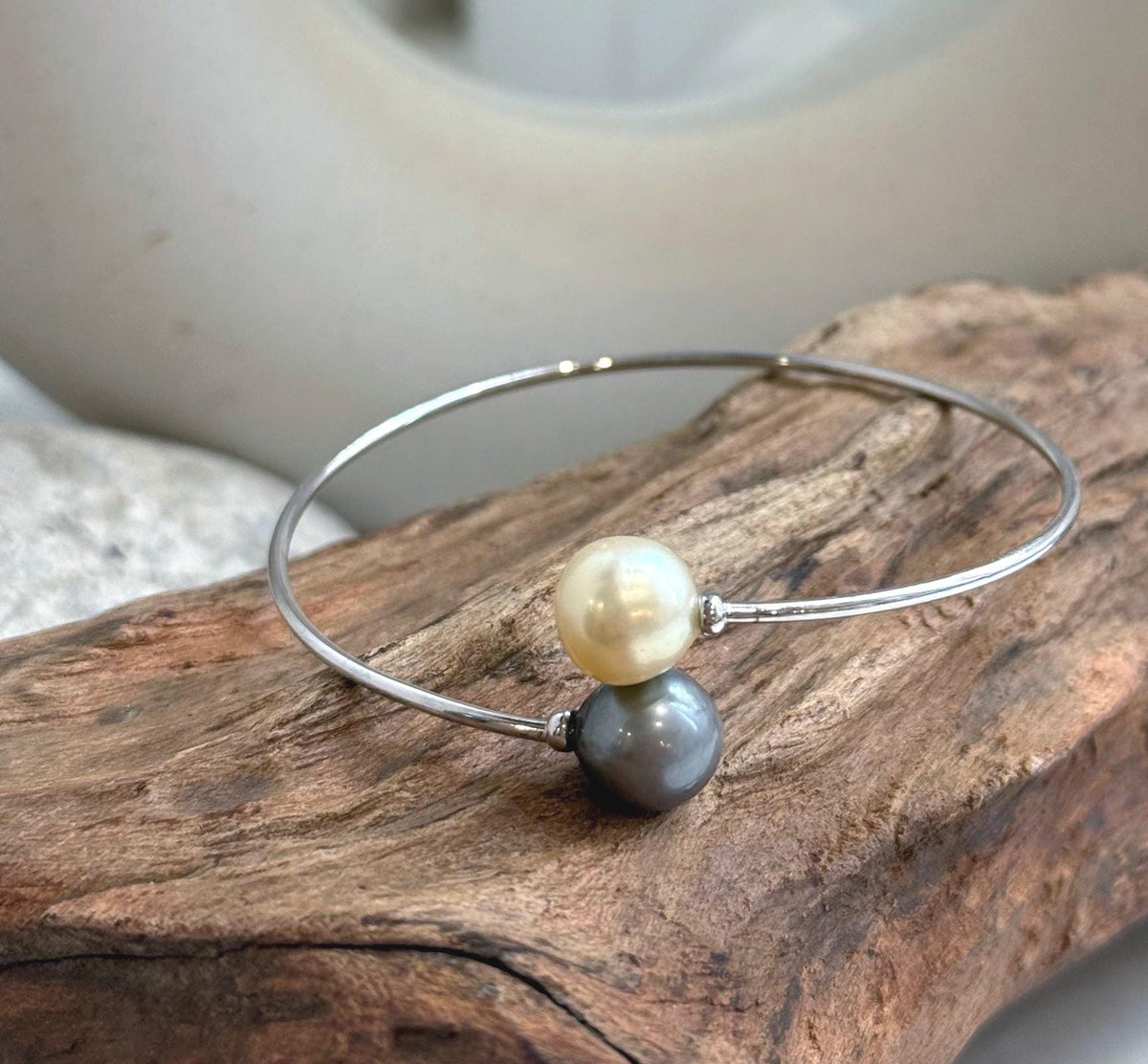 Ocean pearl bracelet with a polished S925 silver band and contrasting pearl colors.
