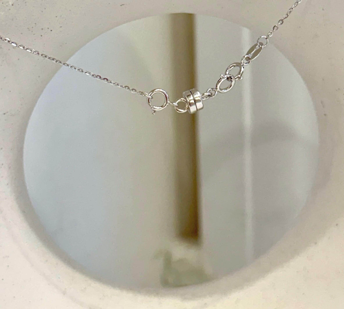 Open circle pearl pendant with a warm gold-tone finish and a lustrous taupe center.