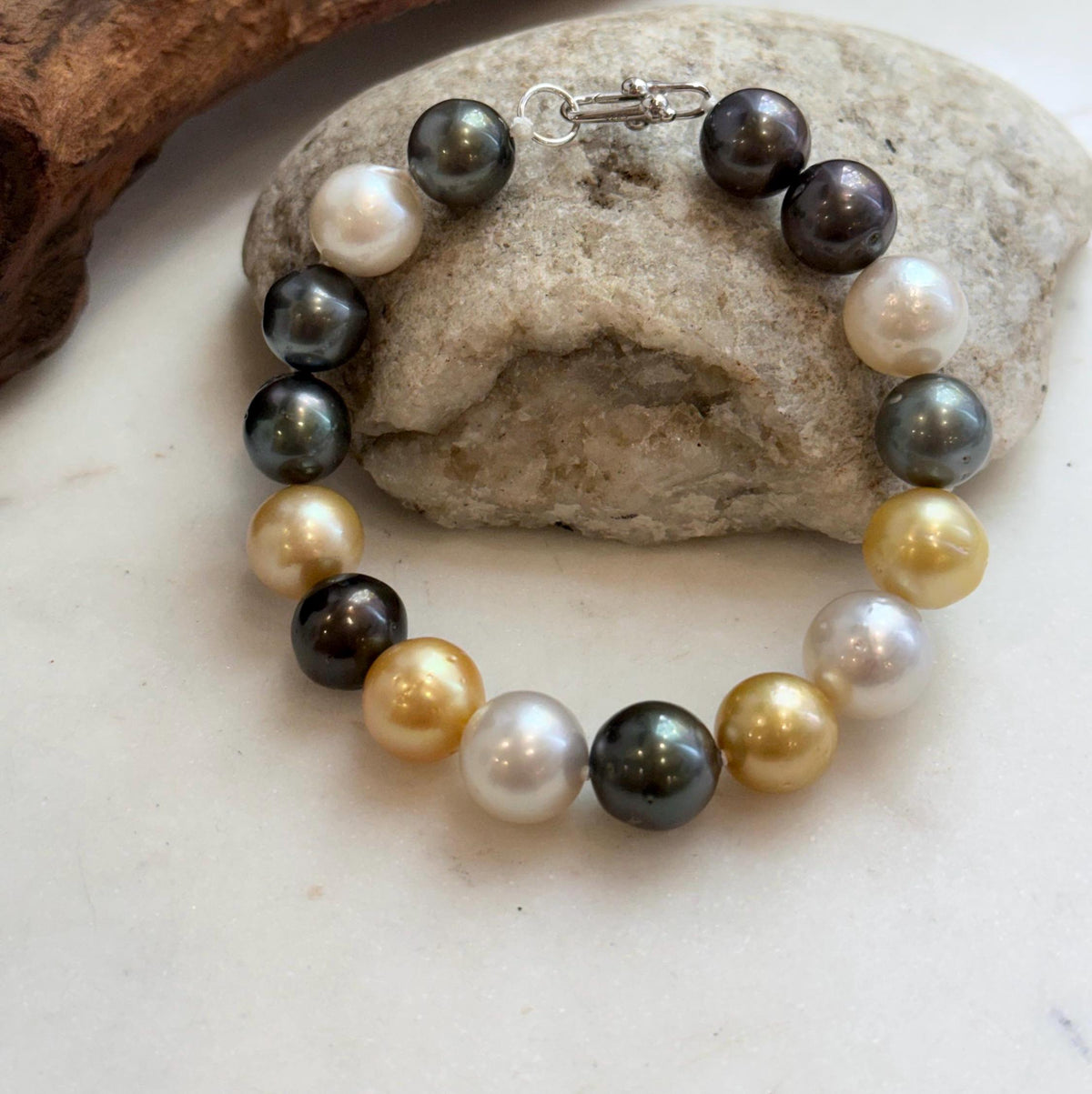 Dark ocean pearls reflecting green and blue overtones.