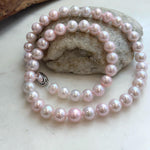 Lustrous pale pink pearls on a hand-knotted necklace.