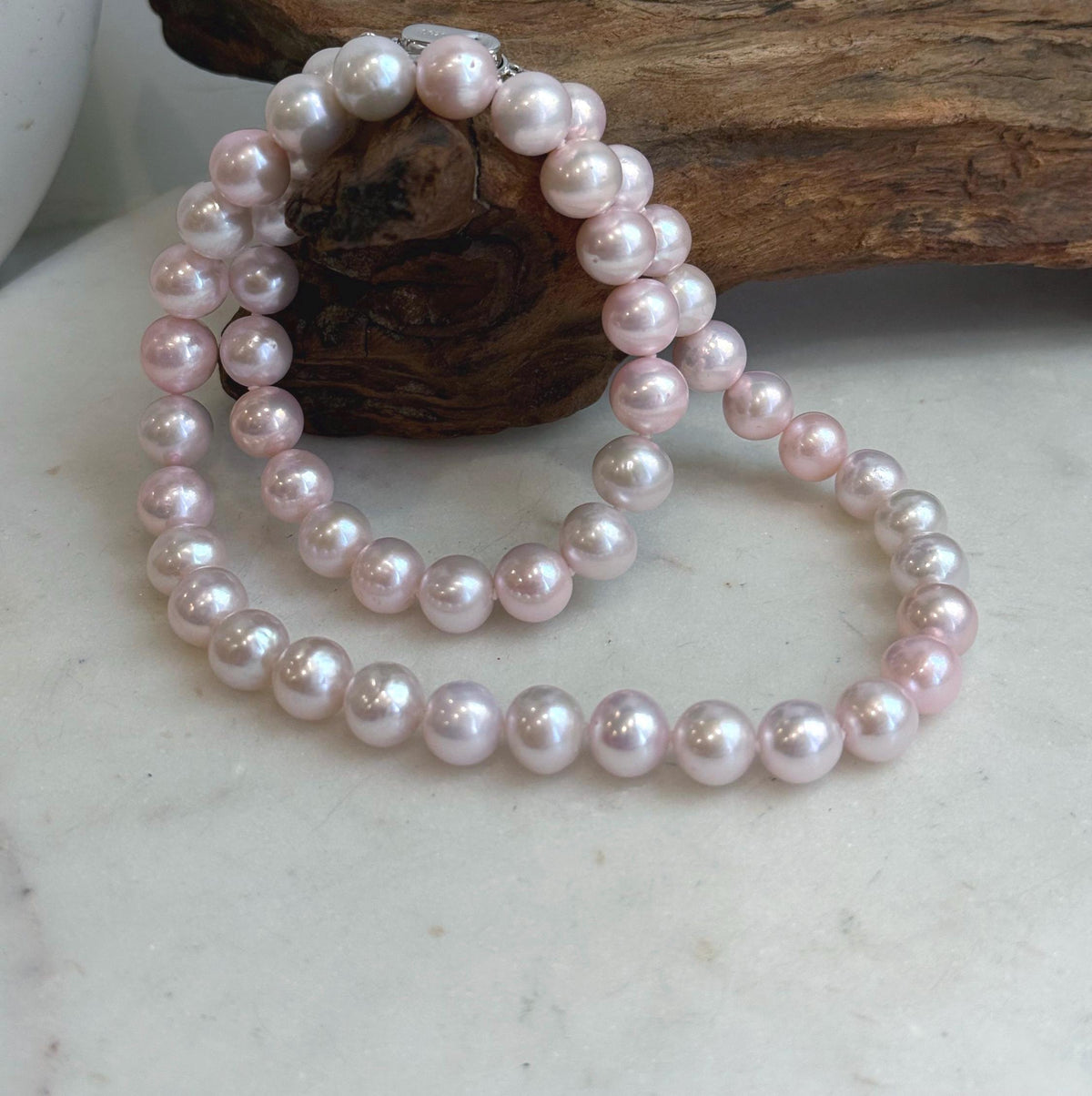 Genuine pale pink freshwater pearls with reflective luster.