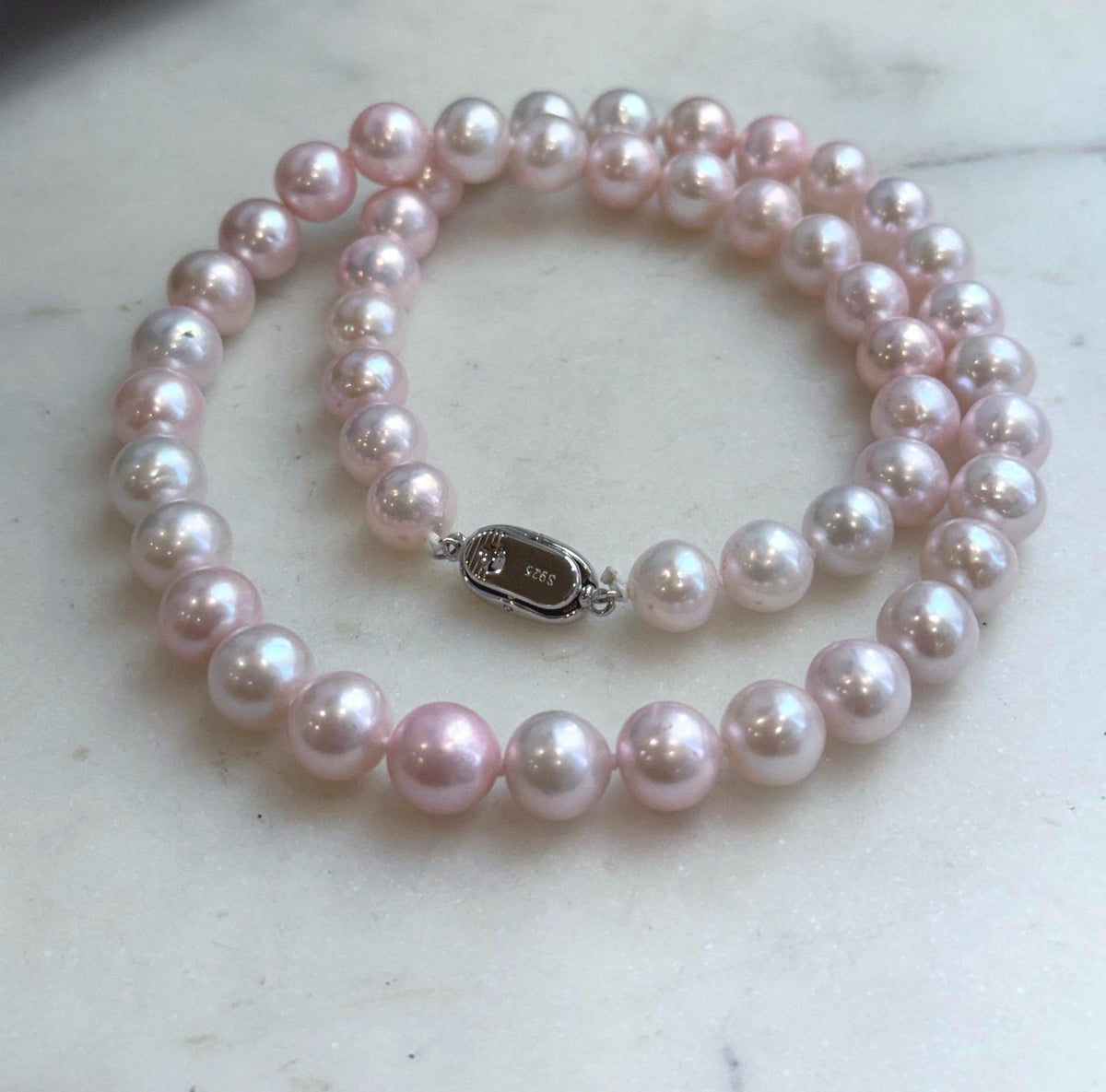 Lustrous freshwater pearl necklace with a soft pink hue.