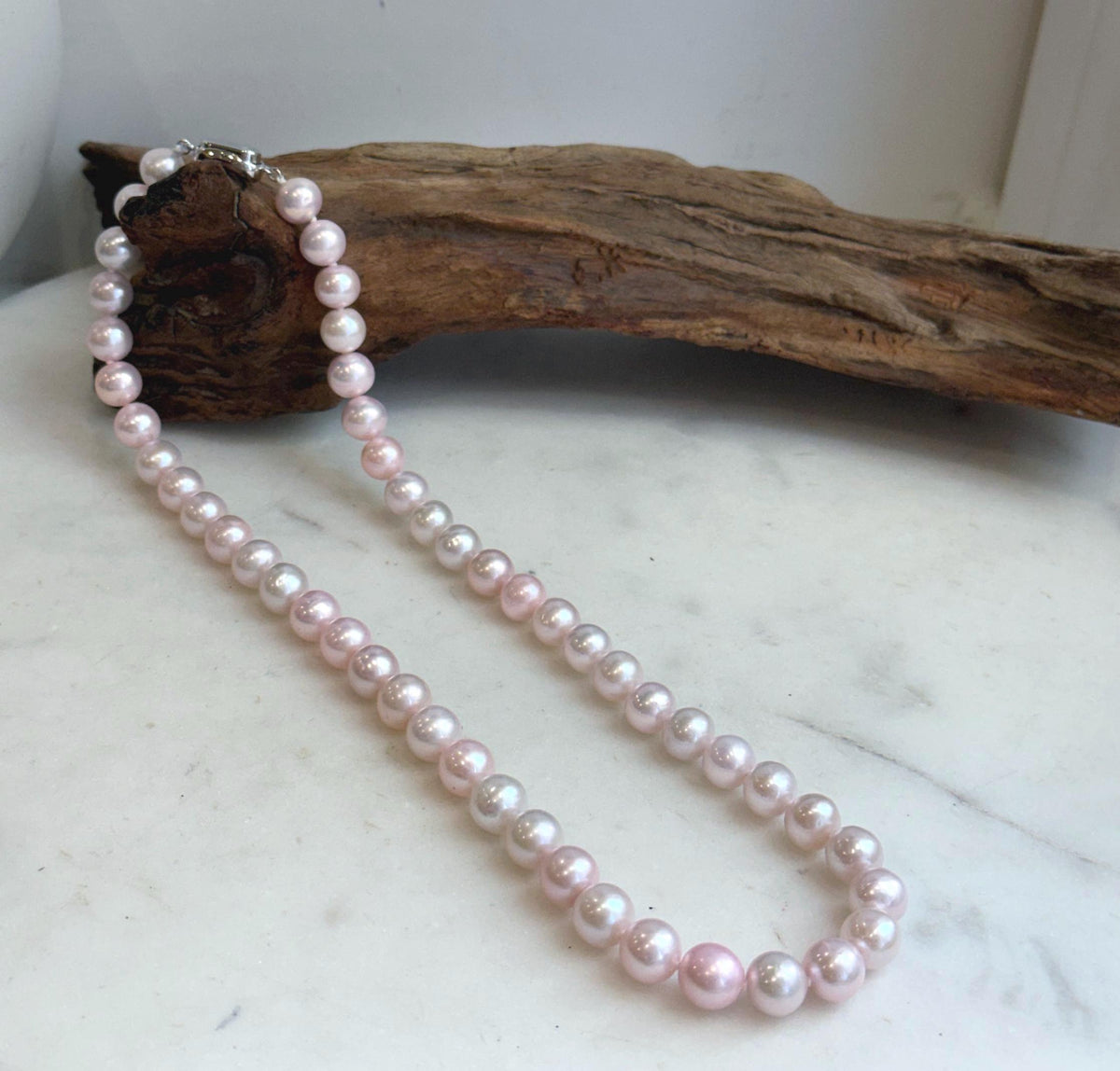 Elly’s hand-knotted pale pink pearl necklace with silver clasp.