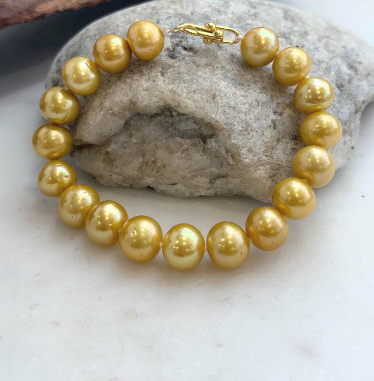 Lustrous golden pearl bracelet with silver fastening