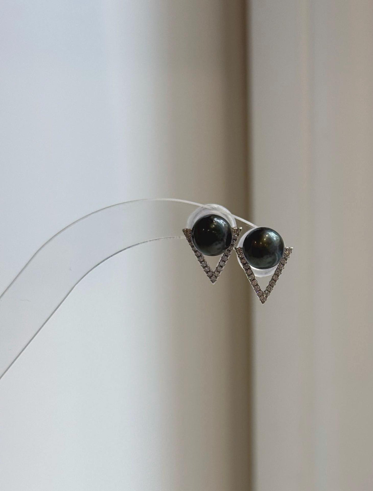 Black hunter green pearl stud earrings with crystal-accented silver triangles.