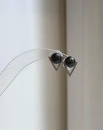 Black hunter green pearls above pointed silver triangle settings.