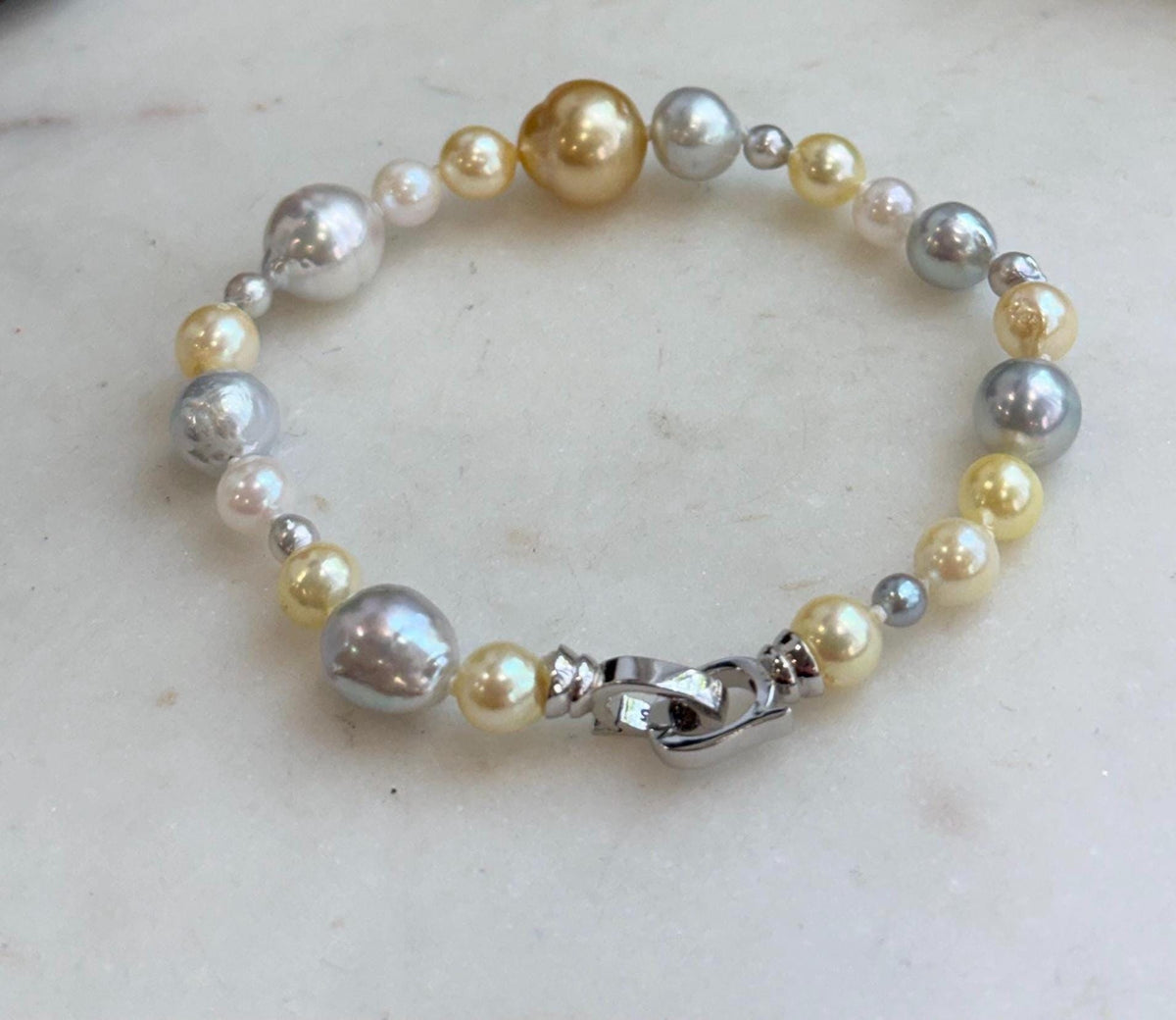 Hand-knotted multicolor pearl bracelet with contrasting pearl sizes.