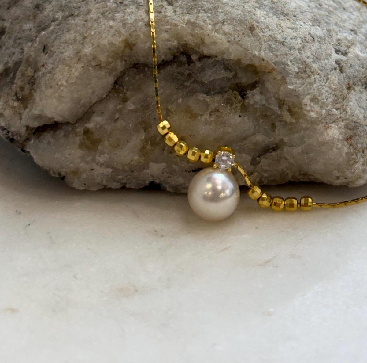 Ivory saltwater pearl necklace combining gold-tone beads with sterling silver details.