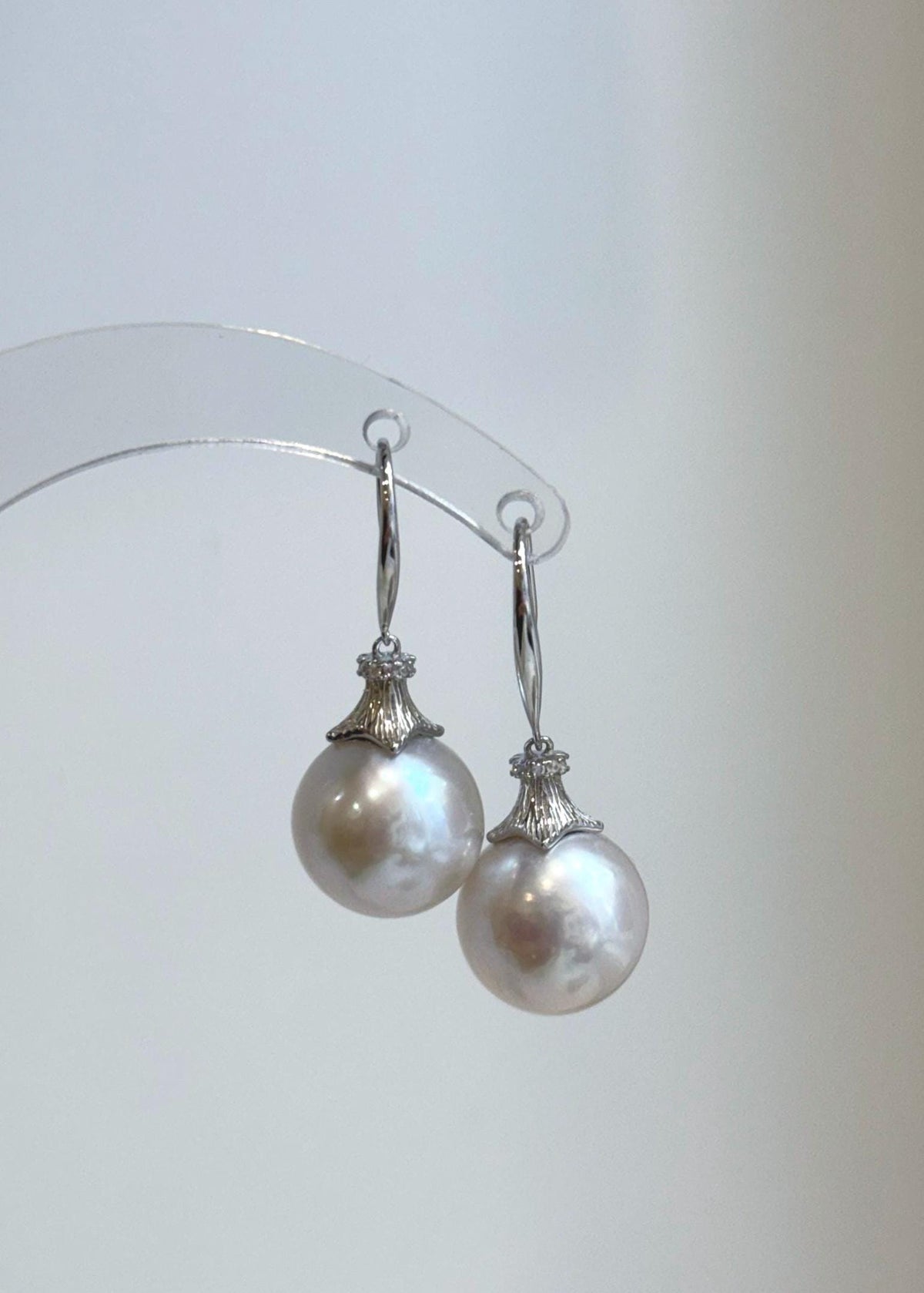 White freshwater pearls reflecting soft pink and blue hues in natural light.