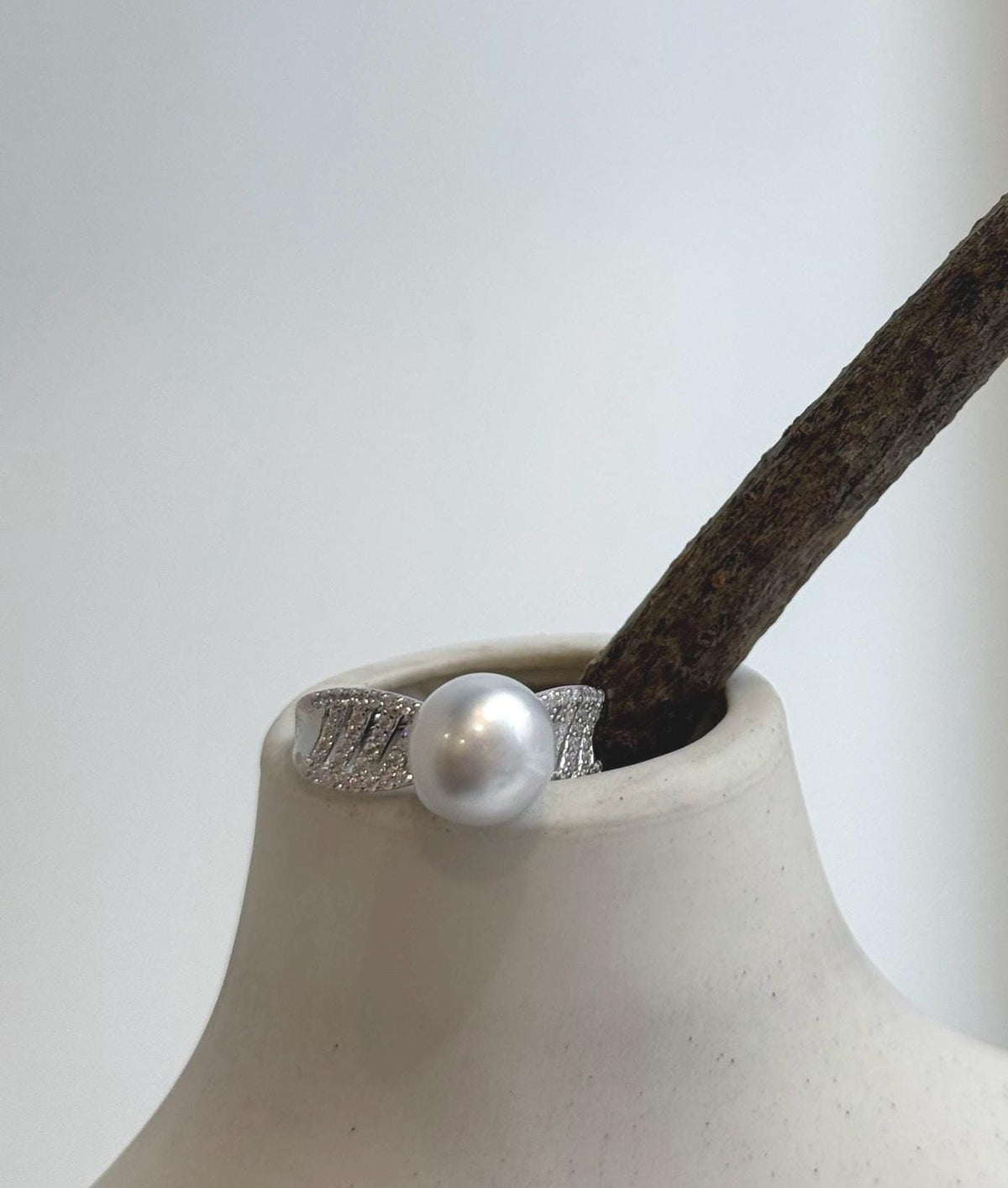 Australian pearl ring with diagonal openwork and sparkling accents on a silver band.