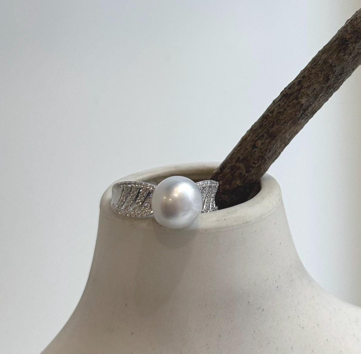 White South Sea pearl above a wide sterling silver band with crystal-accented shoulders.