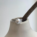 White South Sea pearl above a wide sterling silver band with crystal-accented shoulders.