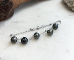 Double chain pearl bracelet featuring dark gray pearls with green and silvery overtones.