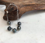 Close view of Tahitian pearls showing reflective luster and varied dark tones.