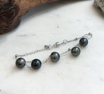 Dark Tahitian pearls linked by fine silver chains with a silver clasp.