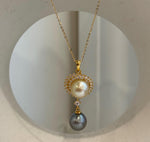 Lustrous platinum gray Tahitian pearl dangling beneath a golden South Sea pearl.