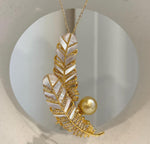 Golden pearl feather pendant displayed on a chain