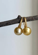 Golden South Sea pearl drop earrings with mirror luster and sculptural silver hooks.