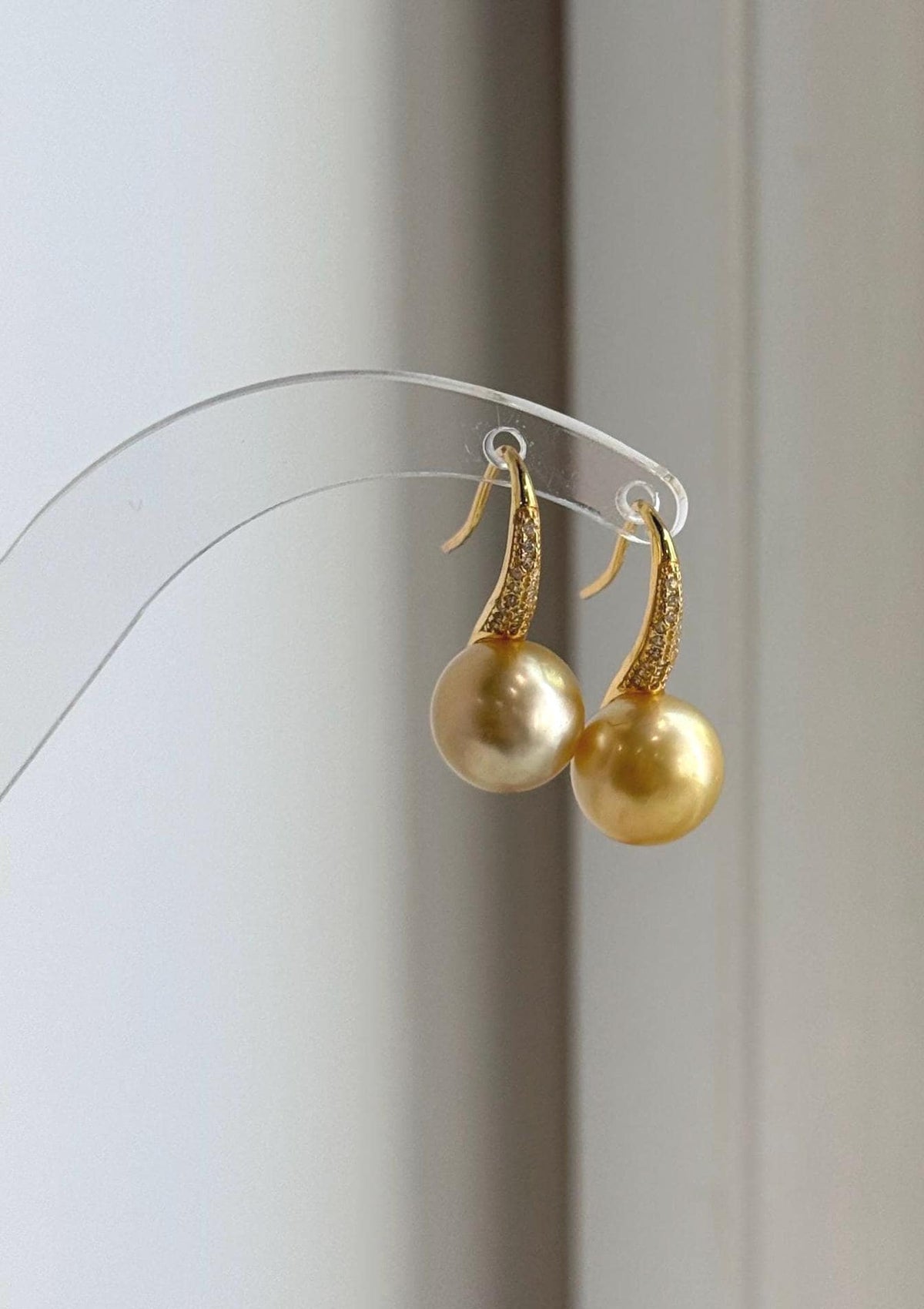 Deep tea golden saltwater pearls suspended from high-heel inspired ear hooks.