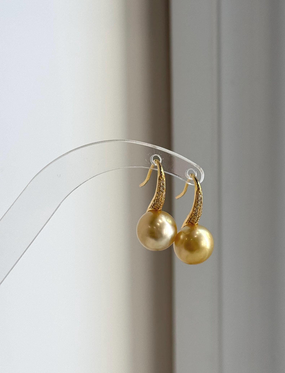 Deep tea gold pearl earrings featuring bright reflective luster.