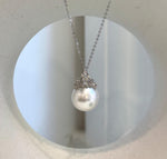 White South Sea pearl crown pendant with a reflective surface and delicate silver detailing.