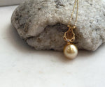 Mirror-luster South Sea pearl in deep tea gold tones, mounted in a sterling silver Lyra pendant.