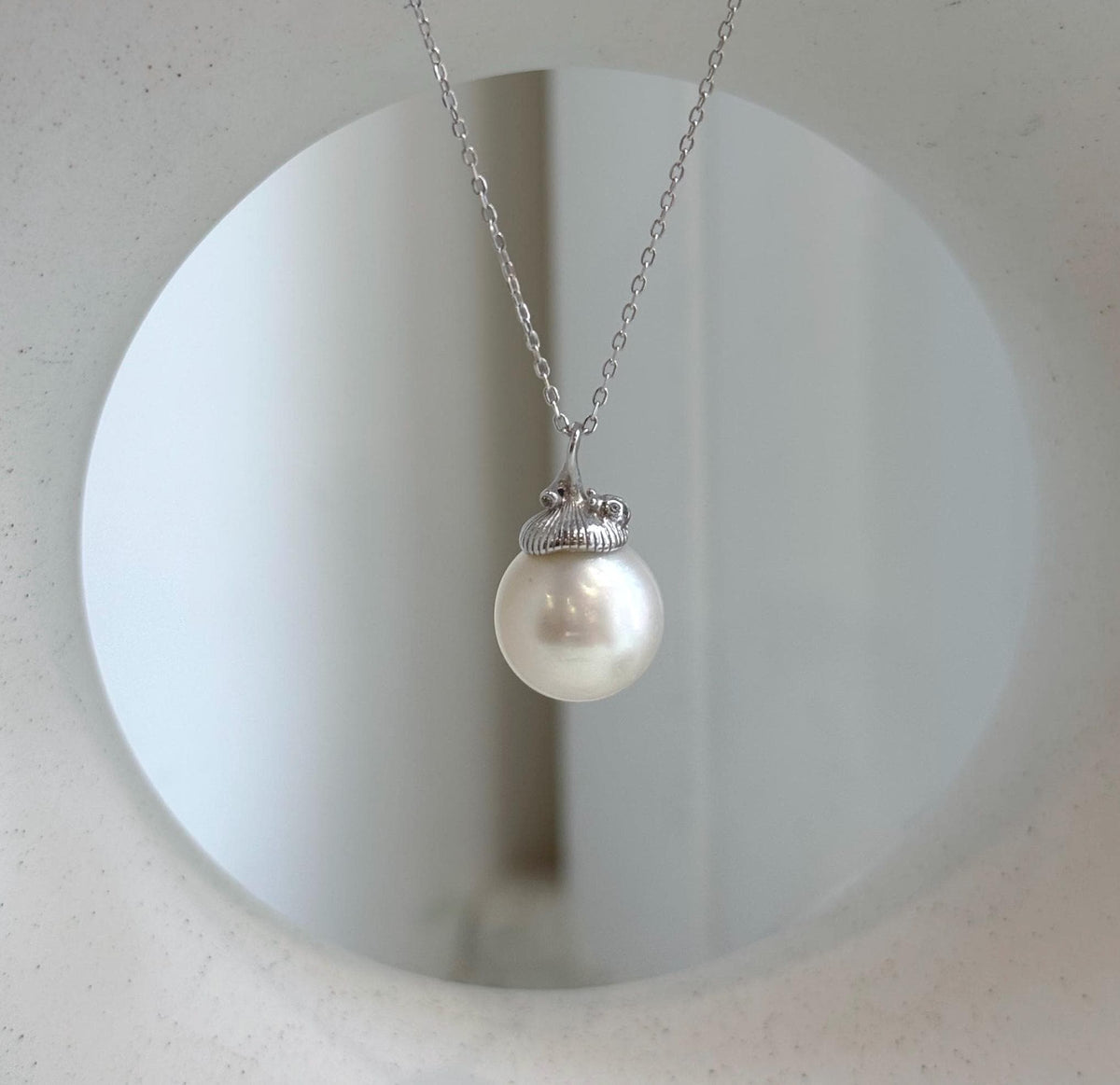 Elly’s Australian white ocean pearl pendant with an acorn design and extreme luster.