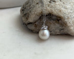 Australian pearl pendant featuring a rounded white pearl and ridged silver cap.