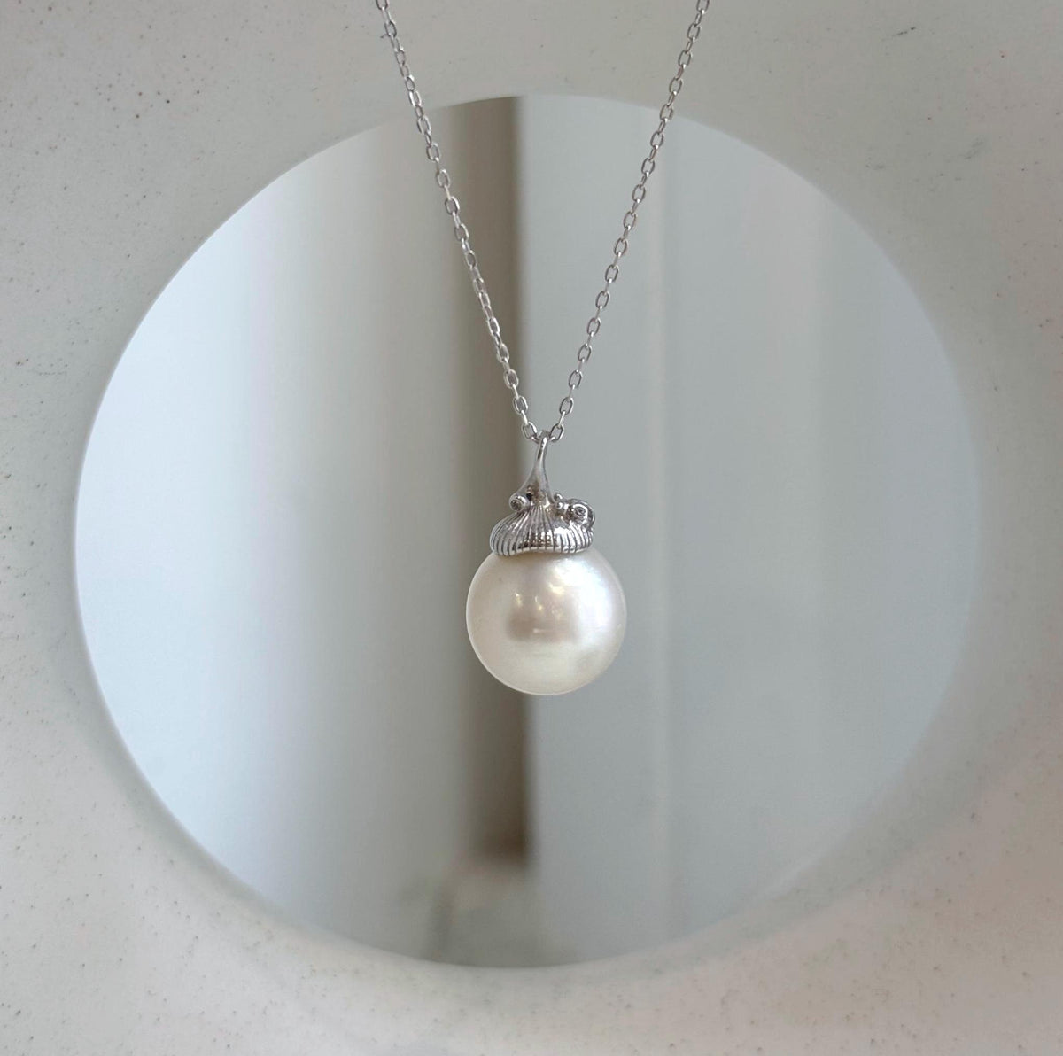 White South Sea pearl with brilliant luster beneath a botanical silver cap.