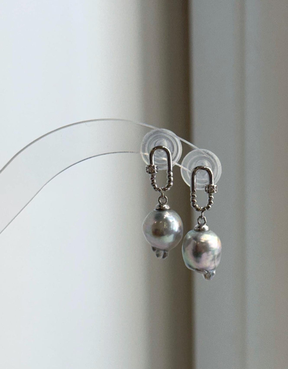Silver blue Akoya pearl earrings photographed in natural light against a neutral background.