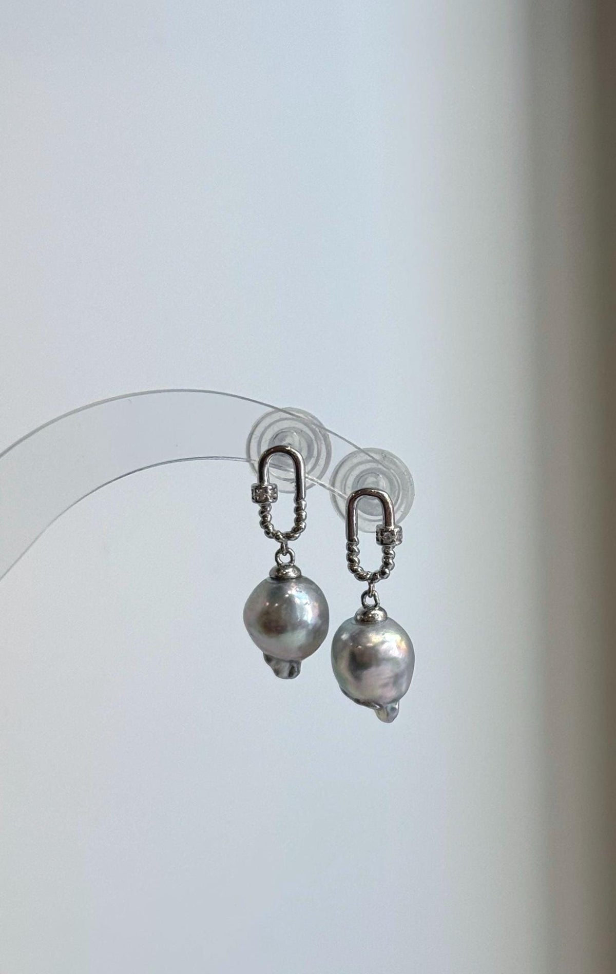 Genuine saltwater Akoya pearl earrings with reflective luster and sterling silver settings.