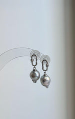 Genuine saltwater Akoya pearl earrings with reflective luster and sterling silver settings.