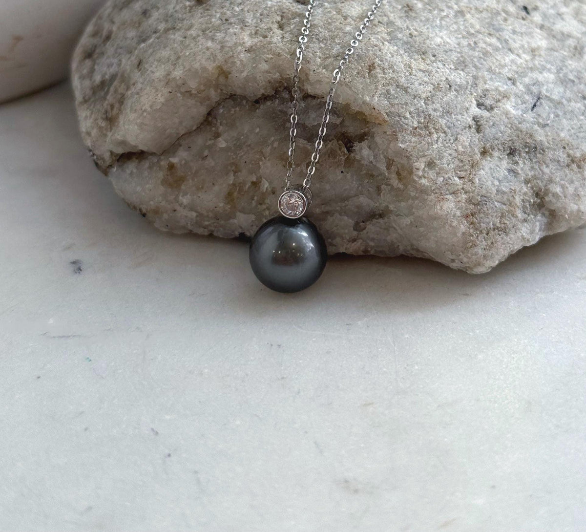 Mirror-luster Tahitian pearl necklace with a crystal-accented silver setting.