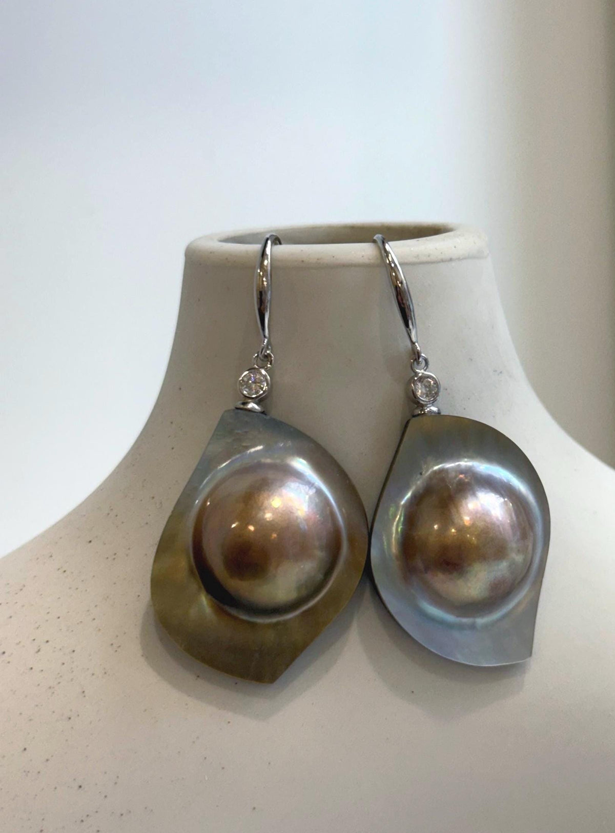 Iridescent mabe pearl drop earrings with sterling silver settings.