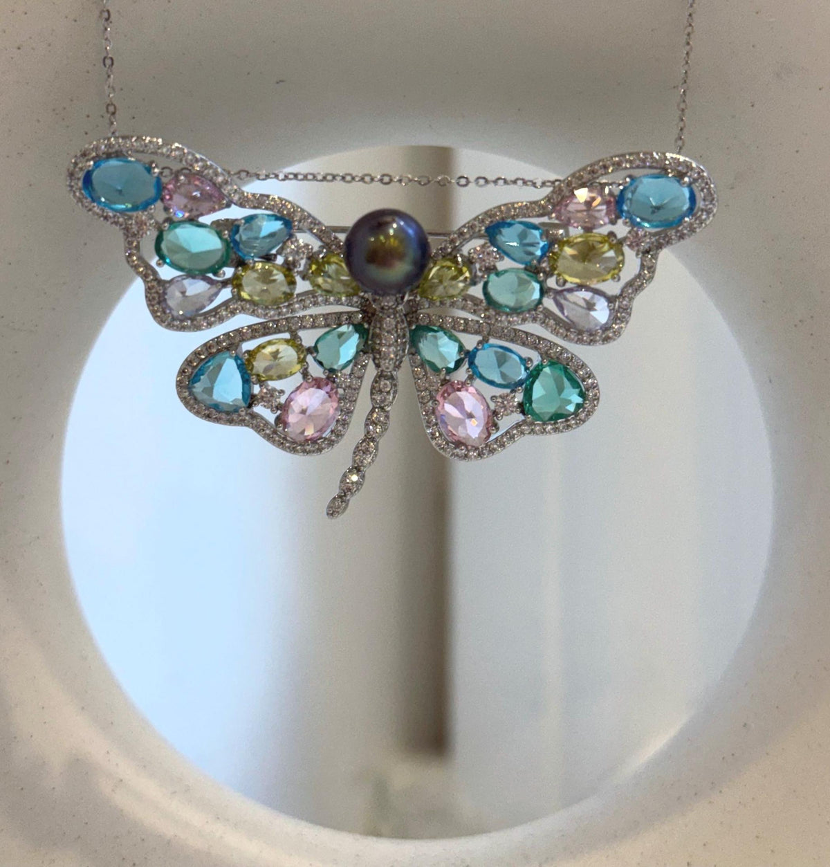 Tahitian pearl centerpiece paired with colorful sparkling butterfly wings.