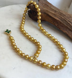 Long golden Edison pearl necklace with mirror-like shine.