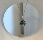 Silver and green Tahitian pearl pendant necklace with a highly reflective surface.