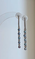 Freshwater pearl earrings showing blue, green, and purple tones.