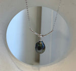 Adjustable sterling silver necklace with a hunter green Tahitian pearl and polished curved bar.