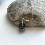 Sterling silver curved bar necklace with a central knot and dangling Tahitian pearl.