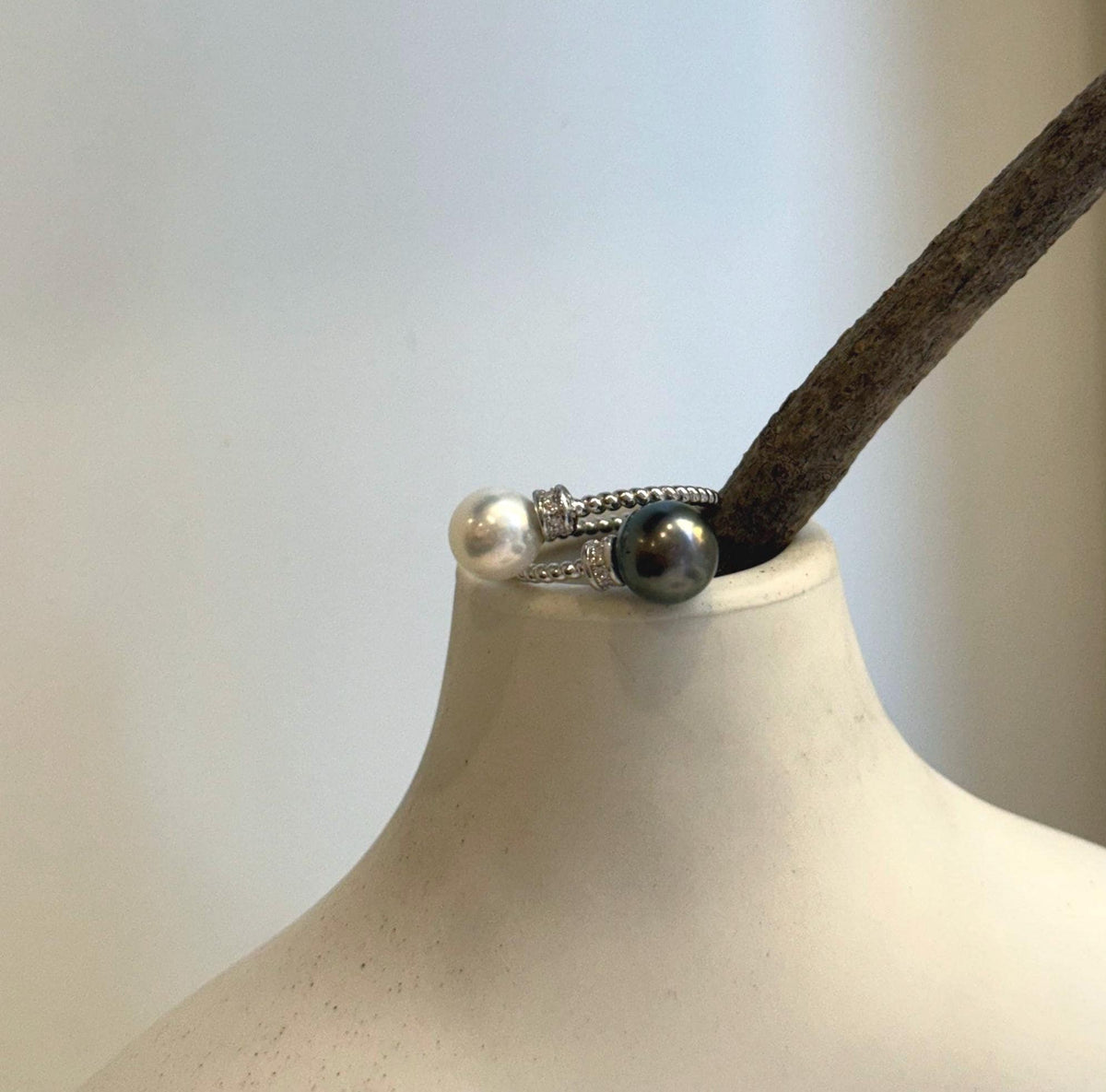 Sterling silver pearl ring highlighting the reflective surfaces of two genuine pearls.