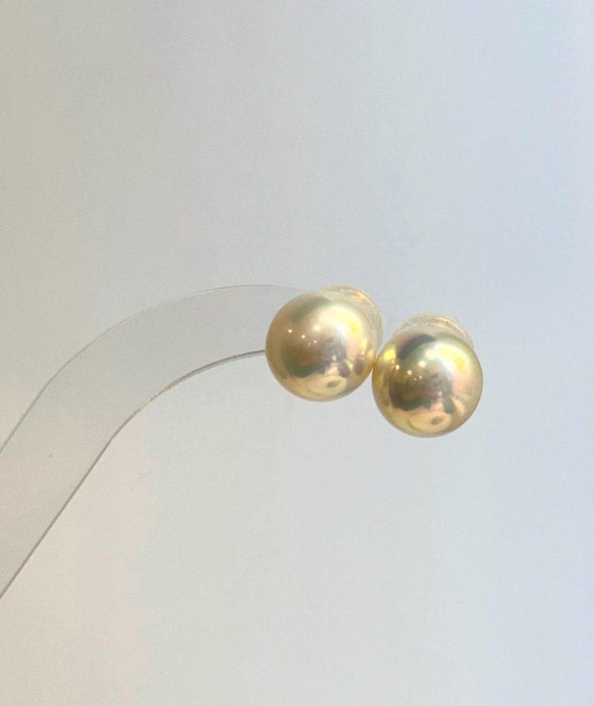 Edison pearl studs with warm champagne gold tones and mirror luster