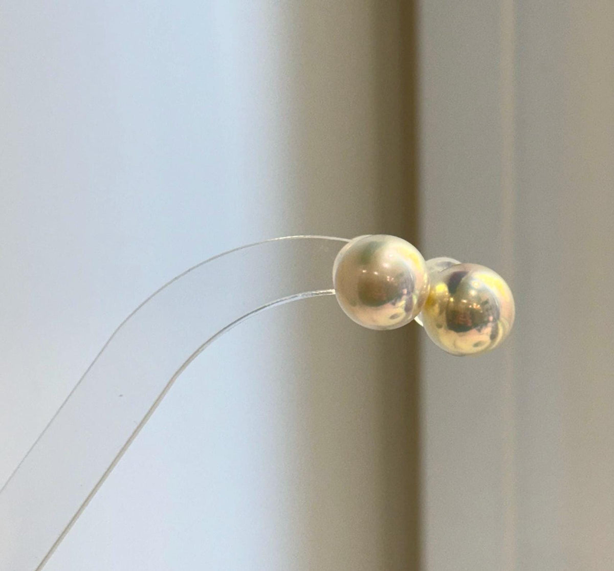 Champagne gold pearl studs featuring a highly reflective surface