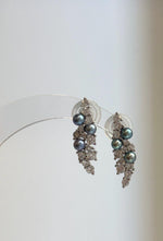 Leaf-shaped silver earrings featuring blue, green and purple freshwater pearls.